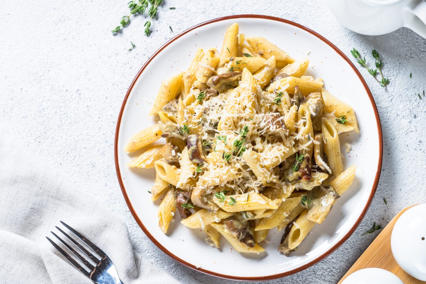 Penne rigate pasta with mushrooms and leeks on white dish